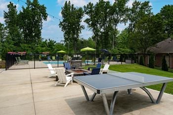 a ping pong table on a patio next to a pool